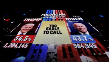 A giant screen shows a broadcast of the 2020 election in Michigan. Pic: Reuters