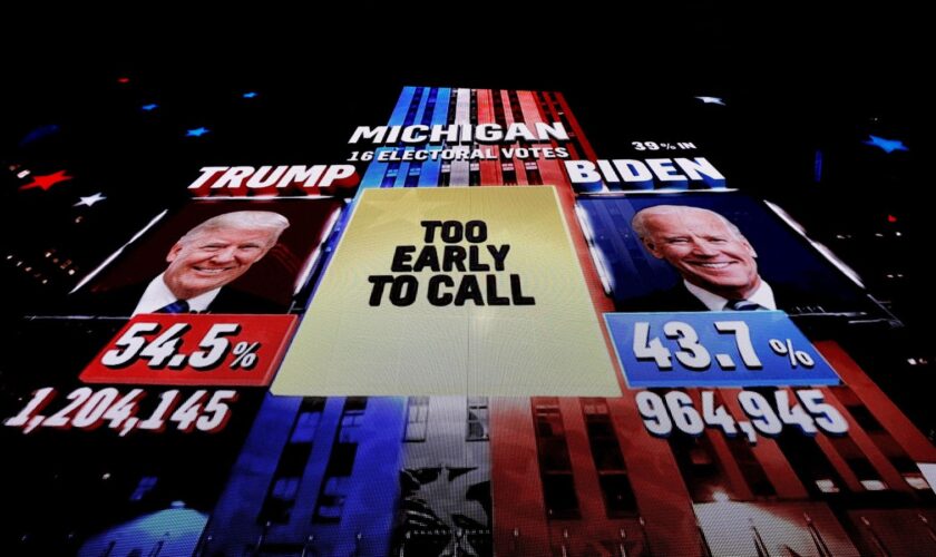 A giant screen shows a broadcast of the 2020 election in Michigan. Pic: Reuters