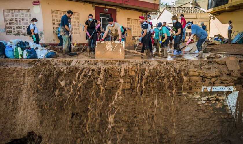 Volunteers and residents cleanup the mud four days after flash floods swept away everything in their path in Paiporta, outskirts of Valencia, Spain, Saturday, Nov. 2, 2024.(AP Photo/Angel Garcia)