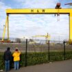 People take pictures of the landmark Samson and Goliath shipbuilding gantry cranes at the Harland & Wolff shipyard in Belfast, Northern Ireland, March 6, 2021. Picture taken March 6, 2021. REUTERS/Clodagh Kilcoyne