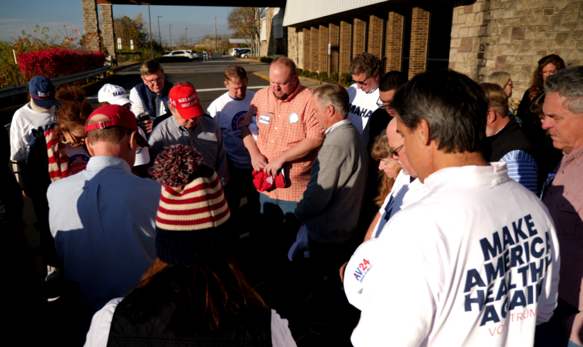 Church minister Michael Hildreth leads the group in prayer before they go out campaigning