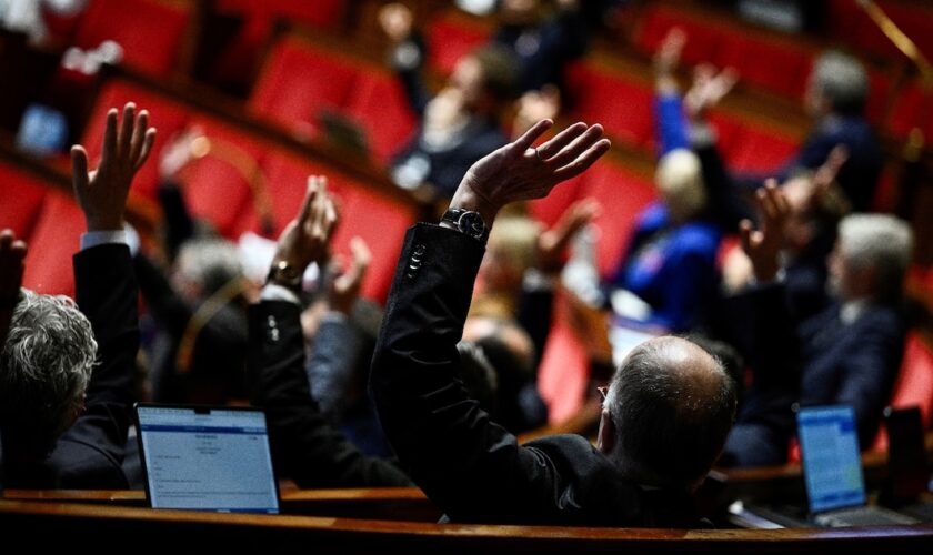 Les députés français votent en levant la main lors d'une séance de débat sur le projet de loi de finances 2025 à l'Assemblée nationale, à Paris, le 24 octobre 2024