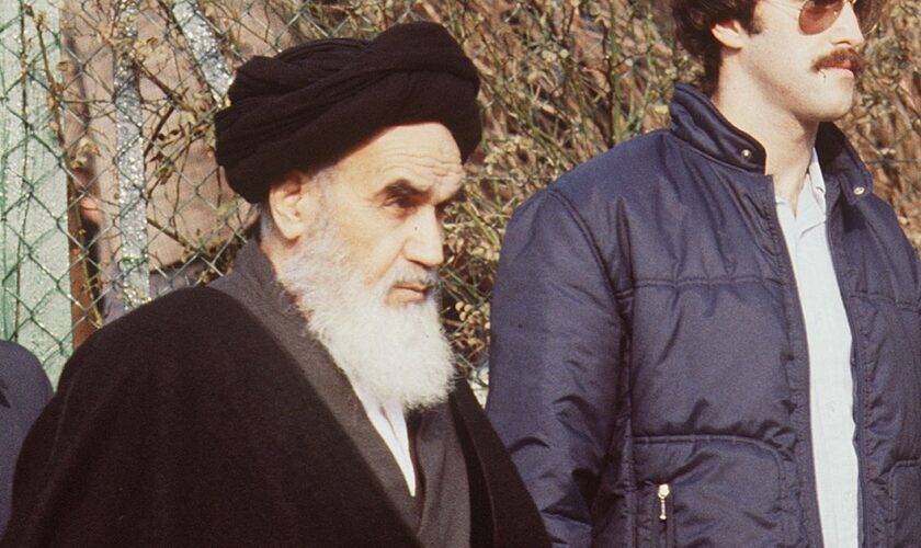 L'ayatollah Khomeiny en exil à Neauphle-le-Château sort de sa villa pour se rendre à la prière en janvier 1979 quelques jours avant son retour à Teheran.