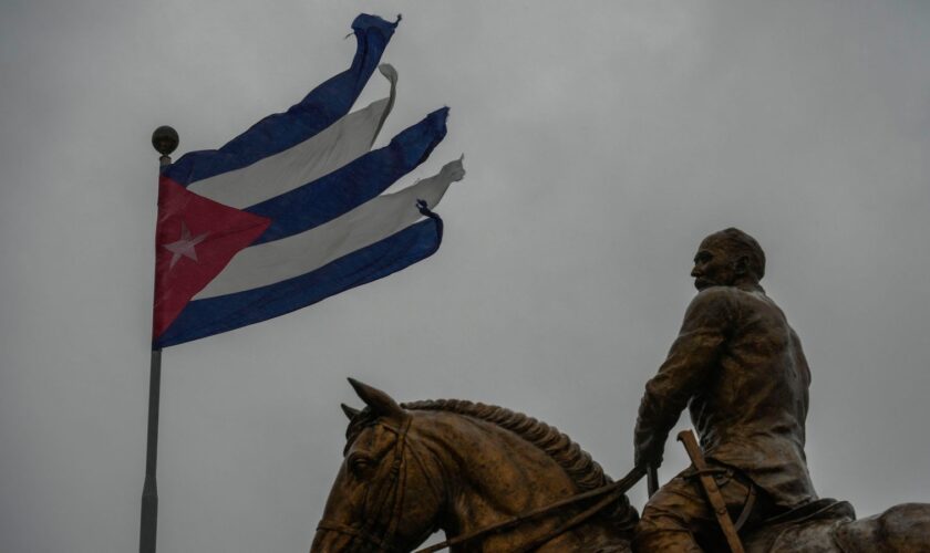 A Cuban flag shredded by the winds of Hurricane Rafael flies above the statue of General Calixto Garcia in Havana, Cuba Pic: AP