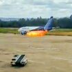 Terrifying moment passengers leap from plane emergency exit as flames billow from engine