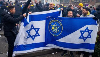 Les supporters du Maccabi Tel Aviv brandissent des drapeaux sur la place du Dam avant le match de football de la Ligue Europa entre l'Ajax et le Maccabi Tel Aviv, à Amsterdam, le 7 novembre 2024