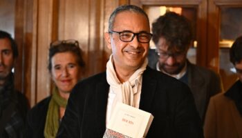 L'écrivain franco-algérien Kamel Daoud (c), lauréat du prix Goncourt pour son roman "Houris", au restaurant Drouant à Paris, le 4 novembre 2024