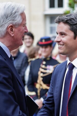 Michel Barnier sert la main du Premier ministre sortant Gabriel Attal lors de la cérémonie de passation de pouvoir à l'Hotel Matignon à Paris, le 5 septembre 2024