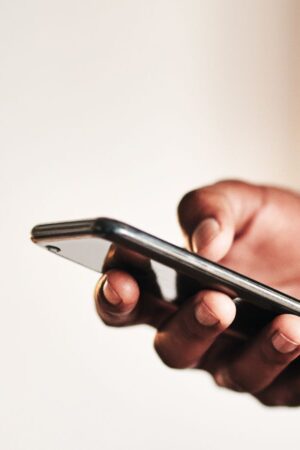 Cropped shot of an unrecognizable businessman standing alone in his home office and texting on his cellphone