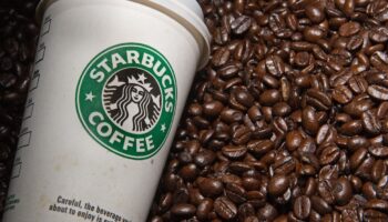 Gobelet de l'enseigne américaine Starbucks au milieu de grains de café le 12 août 2009 à Washington