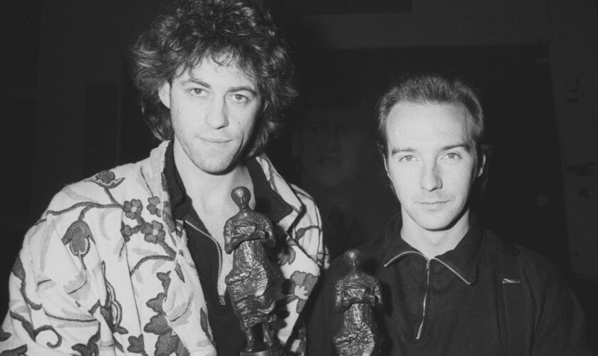 Midge Ure (R), 31, of the rock group Ultravox, with Bob Geldof at the Ivor Novello Awards for 1984 at the Grosvenor House Hotel, London. The pair won a joint award for the Band Aid single 'Do They Know It's Christmas?"