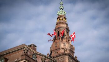 Des drapeaux danois flottent au sommet du château de Christiansborg avant l'ouverture de la session parlementaire au Parlement danois à Copenhague, le 4 octobre 2022