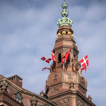 Des drapeaux danois flottent au sommet du château de Christiansborg avant l'ouverture de la session parlementaire au Parlement danois à Copenhague, le 4 octobre 2022