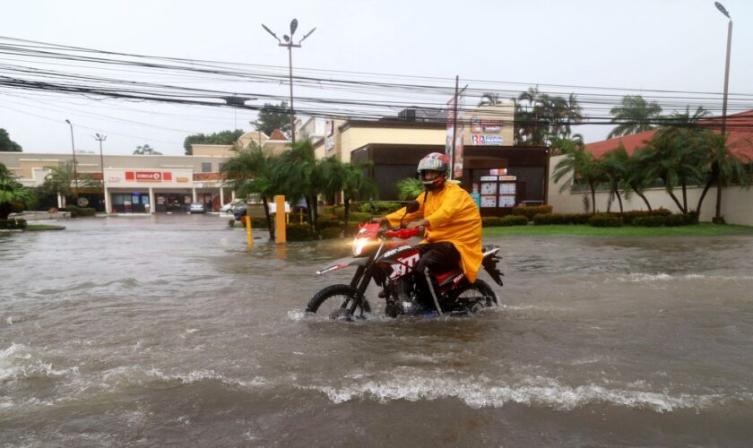 A motorcyclist in a flooded street in La Ceiba, Honduras. Pic: Reuters