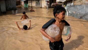 Children play along a flooded street following super typhoon Man-Yi, in Cabanatuan, Nueva Ecija, Philippines, November 18, 2024. REUTERS/Lisa Marie David TPX IMAGES OF THE DAY