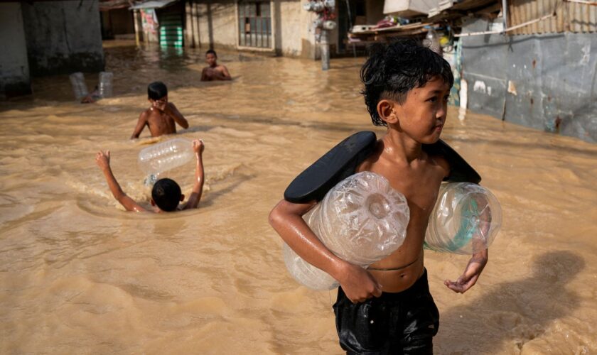 Children play along a flooded street following super typhoon Man-Yi, in Cabanatuan, Nueva Ecija, Philippines, November 18, 2024. REUTERS/Lisa Marie David TPX IMAGES OF THE DAY