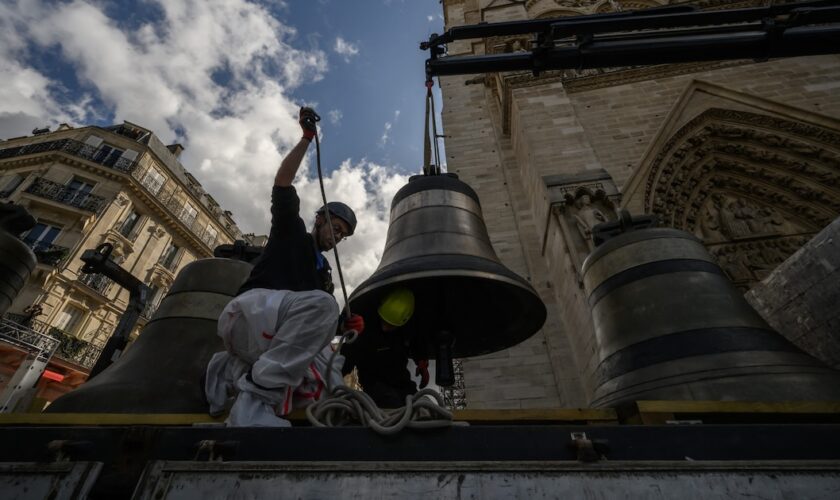 Des ouvriers installent le battant sur l'une des huit cloches de Notre-Dame de Paris.