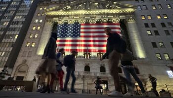 People pass the New York Stock Exchange in New York's Financial District on Tuesday, Nov. 5, 2024. (AP Photo/Peter Morgan)