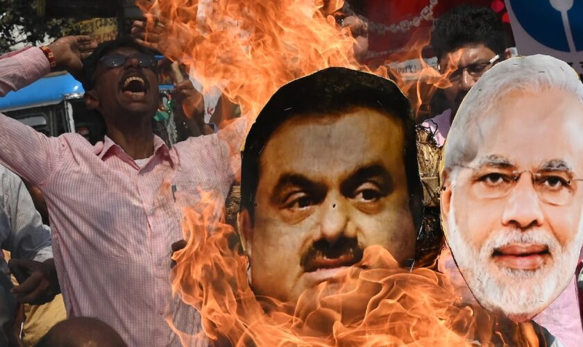 Un militant de l'opposition brûle les effigies du Premier ministre indien Narendra Modi et du milliardaire Gautam Adani pendant une manifestation à Calcutta, le 6 février 2023