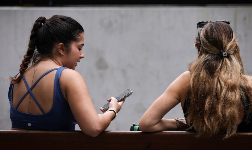 Deux jeunes filles sur leur téléphone à Sydney, le 7 novembre 2024