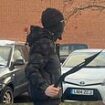 Shocking moment masked thug in balaclava brandishes two machetes outside school in Nottingham