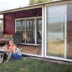 Une mère avec deux enfants et un chien profitant de leur maison-container.