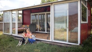 Une mère avec deux enfants et un chien profitant de leur maison-container.