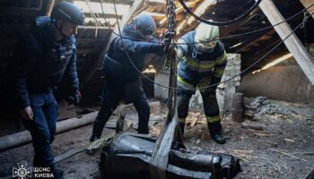 In this photo provided by the Ukrainian Emergency Service, emergency services personnel remove part of a Russian missile that hit an apartment house during massive missile attack in Kyiv, Ukraine, Sunday, Nov. 17, 2024. (Ukrainian Emergency Service via AP)