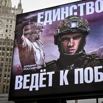 Le siège du mininstère russe des Affaires étrangères à Moscou vu derrière un panneau publicitaire de l'armée avec pour slogan "L'Unité mène à la Victoire!", le 21 novembre 2024