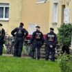 Fünf Polizistinnen und Polizisten stehen vor einem Haus