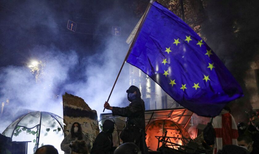 A protester brandishes an EU flag as demonstrations continue in Tbilisi on Saturday. Pic: Reuters