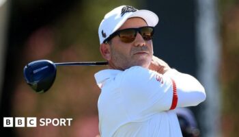 Sergio Garcia in sunglasses with a golf club after taking a shot