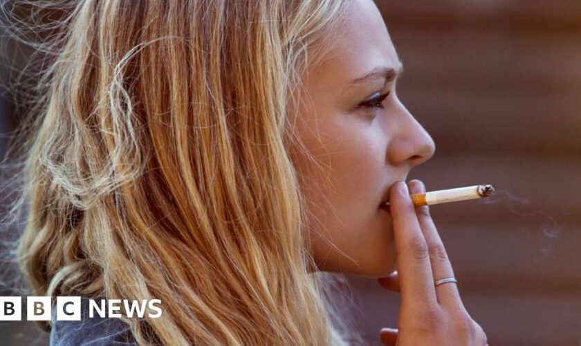 Blonde woman smoking cigarette - stock photo