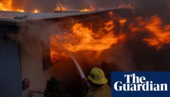 Wind-driven wildfire rages in California with scores of homes charred