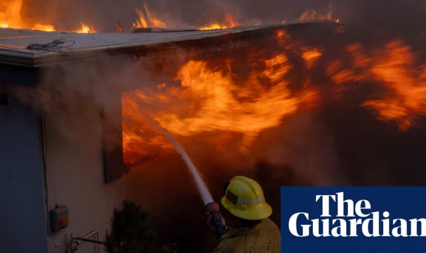 Wind-driven wildfire rages in California with scores of homes charred