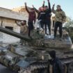 Opposition supporters stand on a captured Syrian army tank near Aleppo. Pic: AP Photo/Omar Albam