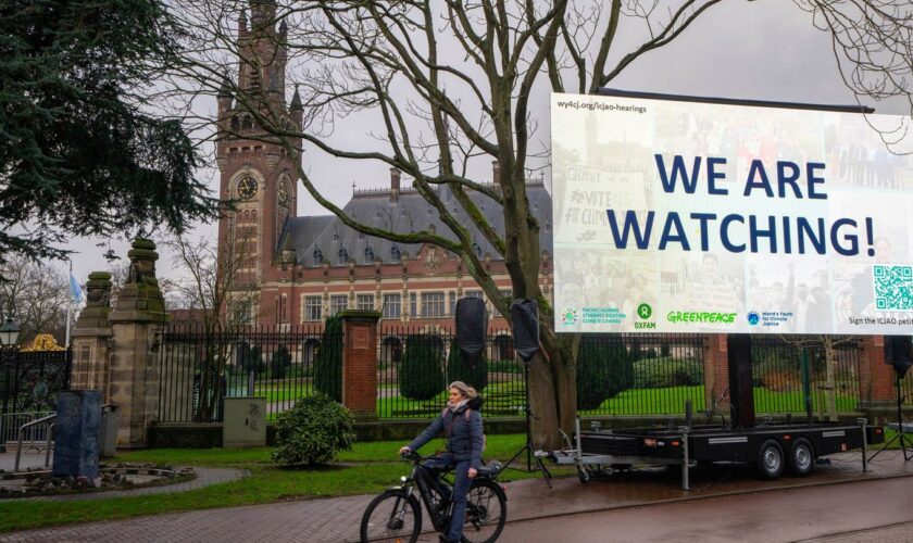 "We are Watching!" ist auf einem Plakat vor dem Internationalen Gerichtshof zu lesen: Das höchste UN-Gericht befasst sich mit Kl