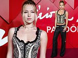 Lila Moss puts on an edgy display in a black lace corset and matching low-rise trousers as she poses at the Fashion Awards 2024