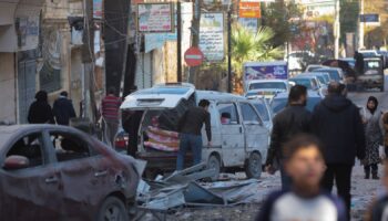 People walk past a damaged site in Aleppo. Pic: Reuters