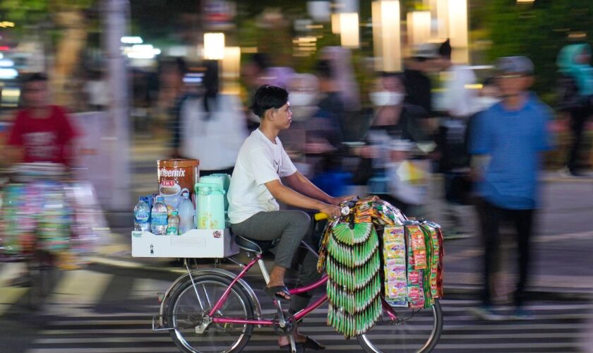 AP PHOTOS: Starlings, Indonesia's bicycle coffee sellers, peddle the streets of Jakarta