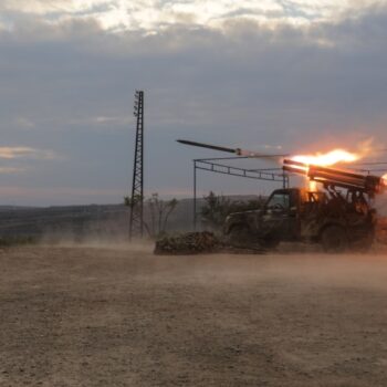 Un combattant antigouvernemental bouche ses oreilles alors qu'un lance-roquette tire un projectile contre les forces gouvernementales syriennes, au nord de Hama, dans le centre de la Syrie, le 4 décembre 2024