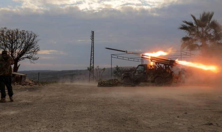 Un combattant antigouvernemental bouche ses oreilles alors qu'un lance-roquette tire un projectile contre les forces gouvernementales syriennes, au nord de Hama, dans le centre de la Syrie, le 4 décembre 2024