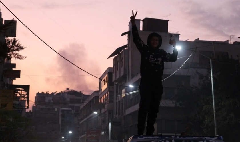 A young boy celebrates the capture of the city by rebel forces