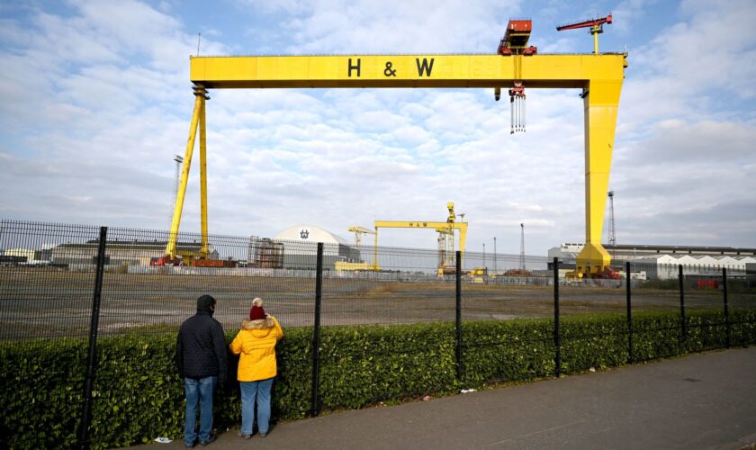 People take pictures of the landmark Samson and Goliath shipbuilding gantry cranes at the Harland & Wolff shipyard in Belfast, Northern Ireland, March 6, 2021. Picture taken March 6, 2021. REUTERS/Clodagh Kilcoyne