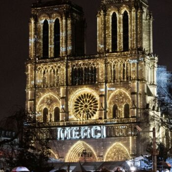 The word 'merci' was projected onto the front of the cathedral. Pic: AP