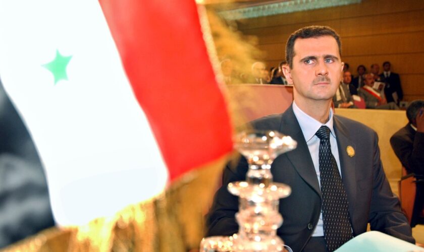 FILE - Syrian President Bashar Assad looks on at his country's flag at the opening of the 16th ordinary session of Arab Summit in Tunis, May 22, 2004. (AP Photo/Amr Nabil, File)