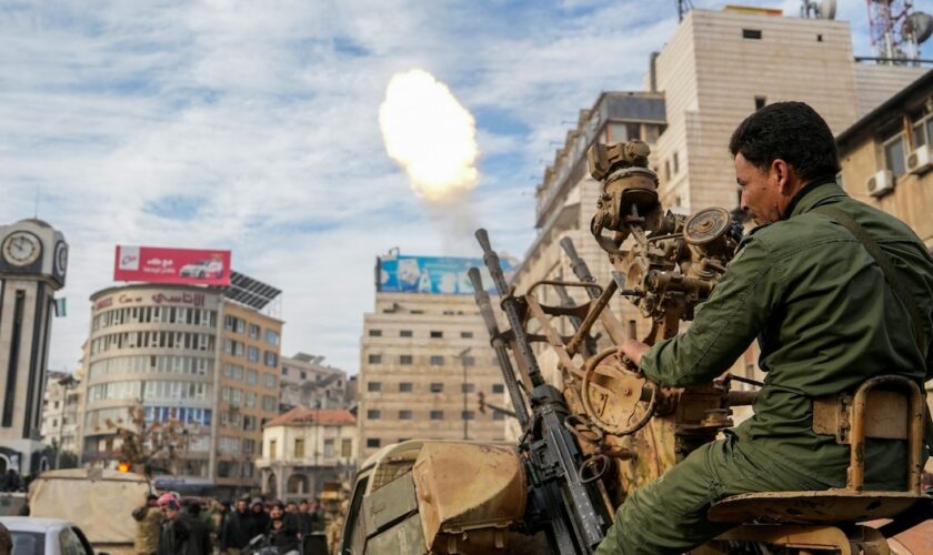 Un combattant rebelle tire en l'air en signe de victoire, à Homs, dans le centre de la Syrie, le 8 décembre 2024