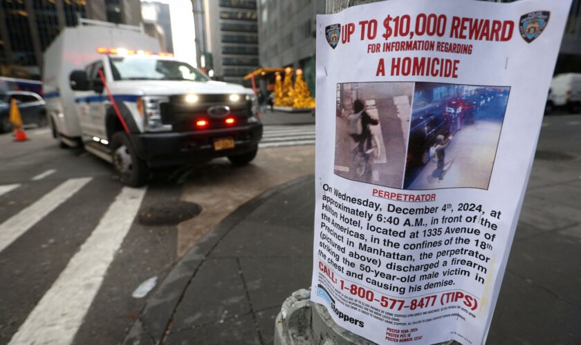 A poster is attached to a lamp post outside the Hilton hotel near the scene where the CEO of UnitedHealthcare Brian Thompson was shot