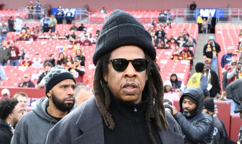 Musician Jay-Z stands on the field before an NFL football game between the Washington Commanders and Dallas Cowboys, Sunday, Nov. 24, 2024, in Landover, Md. (AP Photo/Nick Wass)