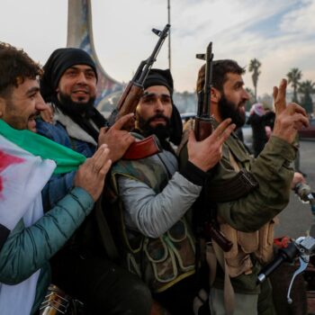 Syrian opposition fighters celebrate after the Syrian government collapsed in Damascus, Syria, Sunday, Dec. 8, 2024. (AP Photo/Omar Sanadiki)